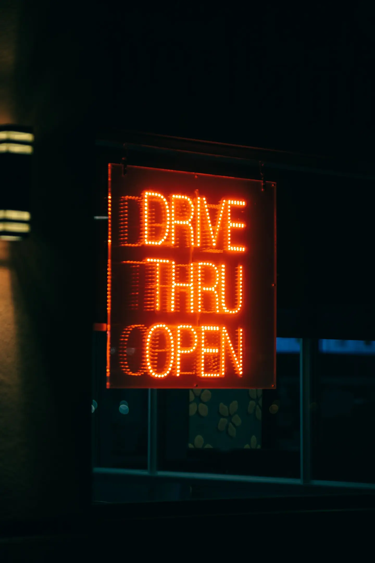 A glowing Drive Thru Open sign at night